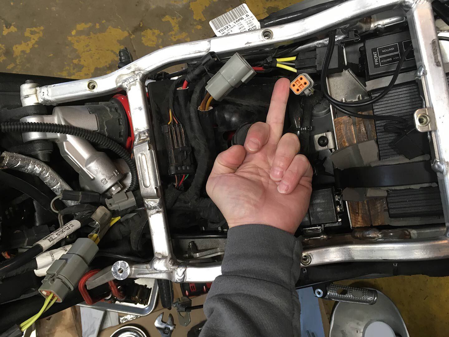 The author noting the location where a failed voltage regulator connects to the wiring harness of his 2009 Buell 1125CR.