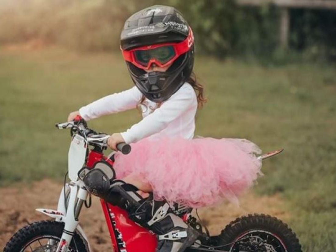 A young lady rider poses with her Oset 12.5R (safety tutu not included with bike).